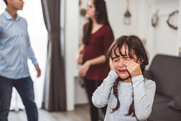 Little girl crying because of her parents quarreling. Girl abused with mother and father shouting...