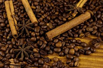 Coffee beans, cinnamon sticks and star anise on rustic wooden background