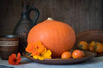 Autumn still life with big pumpkin and persimmon.