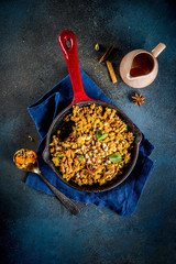 Homemade autumn pastries, pumpkin crumble pie in a cast-iron frying pan, dark blue concrete background, copy space top view