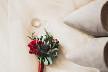 Beautiful toned picture with wedding rings against the background of a bouquet of flowers