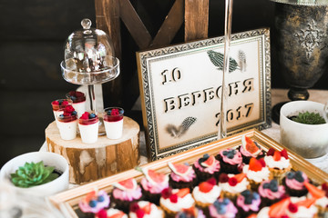 Delicious sweets on wedding candy buffet with desserts, cupcakes