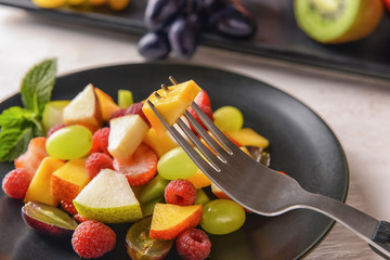 Eating of tasty fruit salad, closeup