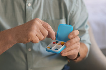 Fototapeta premium Senior man holding container with pills, closeup