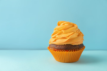 Delicious cupcake on color background