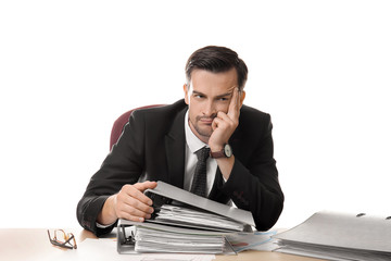 Bored businessman sitting at table with documents against white background