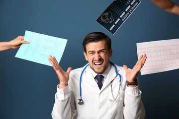 Stressed doctor on color background