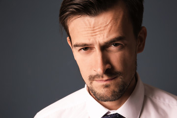 Handsome businessman on grey background