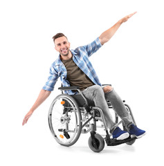 Happy young man sitting in wheelchair on white background
