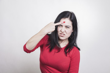 woman in red shirt shows her middle finger to someone who bothered her. she bares her teeth and makes an aggressive expression with her eyebrows