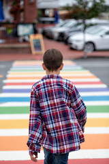 Teenager walking on rainbow crosswalk. sexual identity. coming out. the concept of LGBT. Vertical