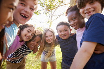 Multi-ethnic group of schoolchildren laughing and embracing