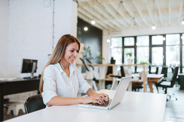 Lovely young woman working in modern co-working office.