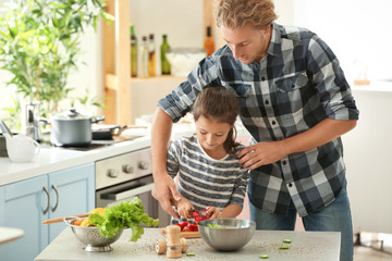 Father and daughter cooking together in kitchen