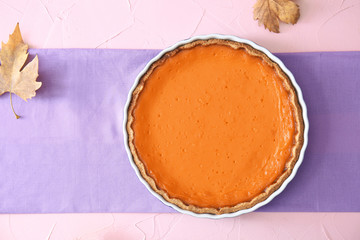 Baking dish with tasty pumpkin pie on table, top view