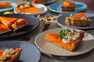 Plates with pieces of tasty pumpkin pie on table