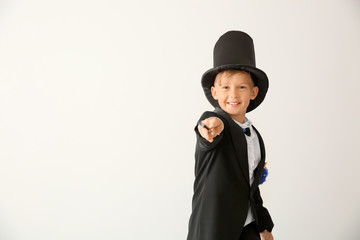 Cute little magician showing tricks on white background