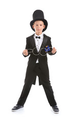 Cute little magician showing trick with rings on white background