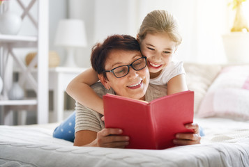 Grandmother reading a book to granddaughter