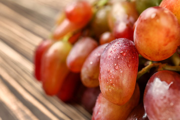 Ripe sweet grapes on wooden table, closeup