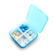 Plastic container with different pills on white background