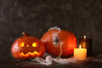 Halloween pumpkins with burning candles on dark background