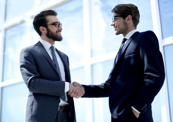 handshake business partners in a bright office