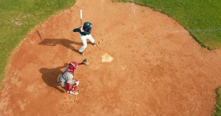 OVERHEAD CRANE Batter baseball player hits a ball over a home plate. 4K UHD 60 FPS SLO MO RAW - Powered by Adobe