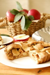 Traditional American Thanks Giving pie, whole & halved apples, cinnamon sticks, anise seeds. Homemade fruit tart baked to golden crust with ingredients. Close up, copy space, top view, background.