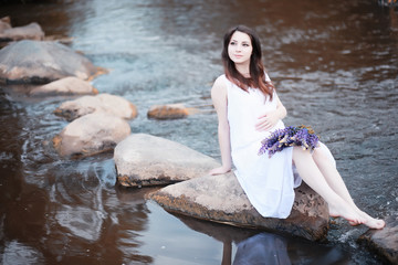 Pregnant woman in nature for a walk in the autumn