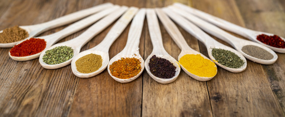 Assorted spices on wooden spoons. Delicious food ingredients.