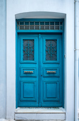 Obraz na płótnie Canvas Fragment of vintage white stone wall with blue door.