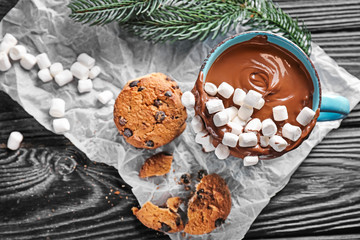 Cup of hot chocolate with marshmallows and cookies on wooden table