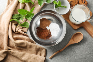 Ingredients for preparing of hot chocolate on grey table
