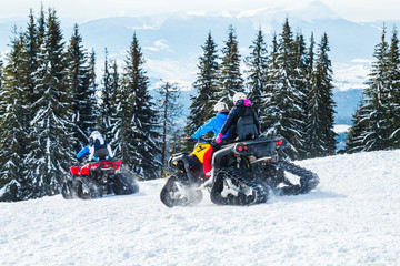 tourists or sportsmen ride mountains on snowmobiles