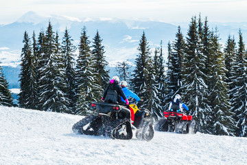 tourists or sportsmen ride mountains on snowmobiles