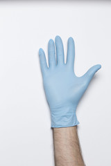 Human hand with blue glove on a light background