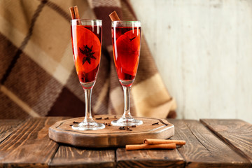 Glasses of delicious mulled wine on wooden board