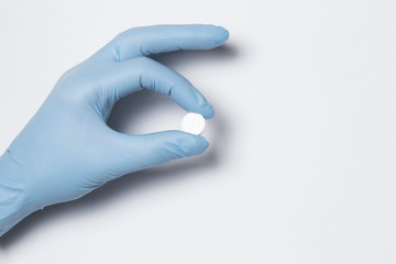 holding pill capsule drugs in hand latex glove white background. medicine for various diseases hospital concept.