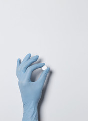 holding pill capsule drugs in hand latex glove white background. medicine for various diseases hospital concept.