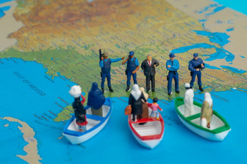 Miniature people concept of Middle Eastern people arrive by boat to the border of USA.