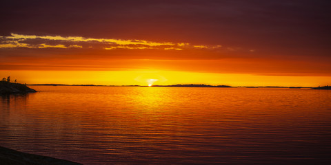 Fototapeta na wymiar The setting sun on the Island of Aspö in Archipelago National Park (Skärgårdshavet nationalpark), Finland, 4 days after the summer solstice.