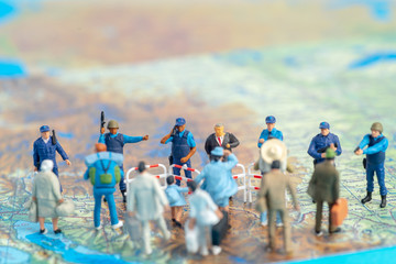 Miniature toy people concept US border patrols against a group of migrant from Mexico