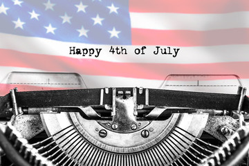 Happy 4th of July, typed text on a vintage typewriter, black ink on old paper in the form of a flag, close-up. America's Independence Day