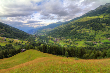 Beautiful view of the Val d’Anniviers valley in Switzerland with the villages saint-luc, saint-jean and vissoie in summer with green fields