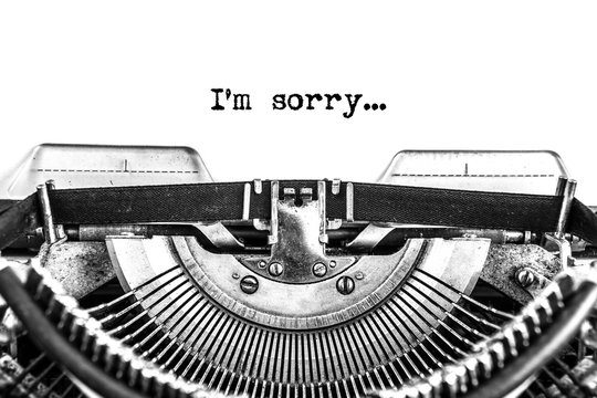 i'm sorry, typed text on a vintage typewriter, black ink on old paper, close-up