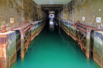 The dock of the Keroman Submarine Base structure K3, a WWII German U-boat facility, in Lorient, France, in summer with emerald green water
