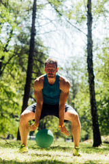 Young man play with medecine ball in the park