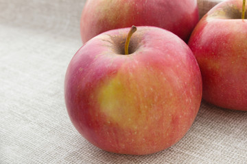 Red apples lie on a natural tablecloth