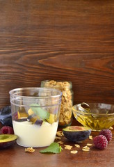 Fototapeta na wymiar Fresh granola, muesli in glass jar, yogurt, honey, plum for healthy breakfast, vertical , copy space